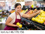 Female seller in apron chooses juicy apple. Стоковое фото, фотограф Яков Филимонов / Фотобанк Лори