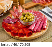Cold cuts from ham, sausages on wooden plate. Стоковое фото, фотограф Яков Филимонов / Фотобанк Лори