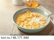 Bowl with healthy cornflakes and milk on light table, closeup. Стоковое фото, фотограф Pixel_shot / Фотобанк Лори