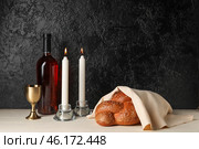 Traditional challah bread with wine and glowing candles on dark background. Shabbat Shalom (2021 год). Стоковое фото, фотограф Pixel_shot / Фотобанк Лори