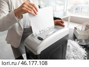 Young secretary destroying paper sheet using shredder in office, closeup. Стоковое фото, фотограф Pixel_shot / Фотобанк Лори