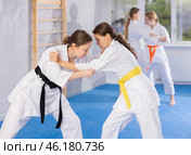 Pairs classes in judo or jiu jitsu - two teenage girls practice grabbing and throwing on sports mats. Стоковое фото, фотограф Яков Филимонов / Фотобанк Лори