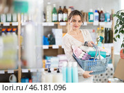 Woman with filled basket wanders around store, looking at display cases, seek something at counter. Стоковое фото, фотограф Яков Филимонов / Фотобанк Лори
