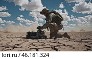 Soldier operating a robot on a dry lake bed. Стоковое видео, видеограф Данил Руденко / Фотобанк Лори