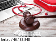 Judge gavel, pills, laptop and stethoscope on wooden background. Concept of health care reform. Стоковое фото, фотограф Pixel_shot / Фотобанк Лори