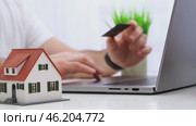 A man buys or chooses real estate over the Internet behind a laptop. Стоковое видео, видеограф Igor Skripachev / Фотобанк Лори