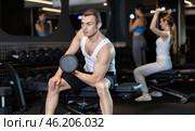 Man trains muscles of arms and back using dumb-bell shaped figure weighting. Стоковое фото, фотограф Яков Филимонов / Фотобанк Лори