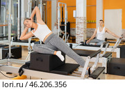 Girl in different poses performs static and dynamic exercises on reformer. Стоковое фото, фотограф Яков Филимонов / Фотобанк Лори