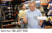 Elderly man choosing paint rollers and brushes. Стоковое видео, видеограф Яков Филимонов / Фотобанк Лори