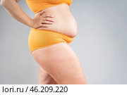 Overweight thighs, woman with fat hips and legs, obesity female body with cellulite on gray background. Стоковое фото, фотограф Станислав Тарко / Фотобанк Лори