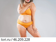 Fat woman in orange underwear on gray background, obesity and cellulite, overweight female body, weight loss concept. Стоковое фото, фотограф Станислав Тарко / Фотобанк Лори