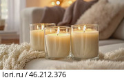 Candles and Soft Textile. Cozy Living Room Details. Flickering burning candle glasses, plush knit blanket. Atmosphere of serenity and comfort. Gray and brown color scheme. Modern boho house interior. Стоковое AI-видео, аниматор Марина Демидюк / Фотобанк Лори