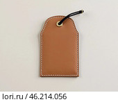 This leather hanging tag sample features a minimalist design with a sturdy loop and a slot for cards. Ideal for customizing luggage or gifts with a touch of elegance. Generative AI. Стоковое AI-изображение, AI-художник Юлия Петровская / Фотобанк Лори