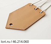 This leather hanging tag sample features a minimalist design with a sturdy loop and a slot for cards. Ideal for customizing luggage or gifts with a touch of elegance. Generative AI. Стоковое AI-изображение, AI-художник Юлия Петровская / Фотобанк Лори