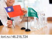 Unrecognizable girl sets midget flags of Saudi Arabia and Taiwan before international negotiations. Стоковое фото, фотограф Яков Филимонов / Фотобанк Лори