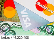 Кредитные карточки с логотипами MasterCard и Visa и рублевые купюры. Редакционное фото, фотограф E. O. / Фотобанк Лори