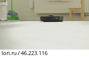 round robot vacuum moves methodically across the bathroom floor, its sensors scanning for dust and hair. Стоковое видео, видеограф Feruza Tashmetova / Фотобанк Лори