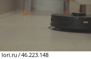 round robot vacuum moves methodically across the bathroom floor, its sensors scanning for dust and hair. Стоковое видео, видеограф Feruza Tashmetova / Фотобанк Лори