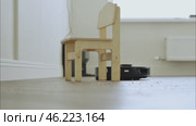 round robot vacuum moves methodically across the bathroom floor, its sensors scanning for dust and hair. Стоковое видео, видеограф Feruza Tashmetova / Фотобанк Лори