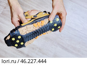 Ice grippers with yellow metal spikes and rubber base are securely fitted to hiking boot for stability on icy terrain. Стоковое фото, фотограф Владимир Григорьев / Фотобанк Лори