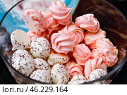 Маленькие безе, розовые и белые, посыпанные шоколадом и орехами, крупным планом в стеклянной миске. Стоковое фото, фотограф Наталья Романюк / Фотобанк Лори