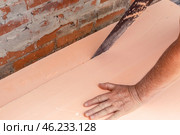 A worker cuts polystyrene foam for laying on the floor. Insulation of the house, installation of a heated floor. Стоковое фото, фотограф Коханова Наталья / Фотобанк Лори