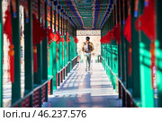 Man passing through the beautiful corridor with Chinese traditional ancient pavilions. Imperial City in the center of Beijing, China (2024 год). Стоковое фото, фотограф Кекяляйнен Андрей / Фотобанк Лори