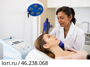 Latin female comsetologist making needle-free mesotherapy for young woman. Стоковое фото, фотограф Яков Филимонов / Фотобанк Лори