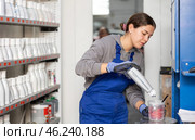 Girl colorist selects paint color by mixing different paint colors for subsequent painting of car in car service center. Стоковое фото, фотограф Яков Филимонов / Фотобанк Лори