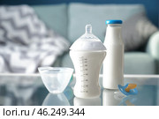 Bottles of baby formula with pacifier on glass table. Стоковое фото, фотограф Pixel_shot / Фотобанк Лори