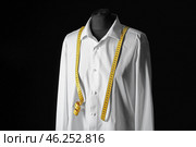 Mannequin with custom tailored shirt and measuring tape on dark background. Стоковое фото, фотограф Pixel_shot / Фотобанк Лори