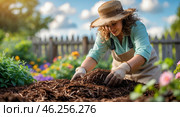 Gardener mulching flower beds on a sunny day in a vibrant garden with colorful blooms in springtime. Стоковое AI-изображение, AI-художник Сергей Толмачёв / Фотобанк Лори