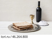 Passover Seder plate with matzo, Jewish cap and wine on table. Стоковое фото, фотограф Pixel_shot / Фотобанк Лори