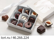 Box with delicious chocolate candies on white wooden background, closeup. Стоковое фото, фотограф Pixel_shot / Фотобанк Лори