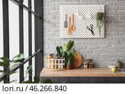 Stylish counter and pegboard on grey brick wall in modern kitchen. Стоковое фото, фотограф Pixel_shot / Фотобанк Лори