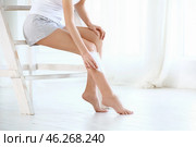 Beautiful young woman epilating legs with wax strip at home. Стоковое фото, фотограф Pixel_shot / Фотобанк Лори