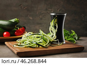 Spiralizer with zucchini noodles on kitchen table. Стоковое фото, фотограф Pixel_shot / Фотобанк Лори
