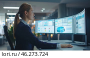 A young woman in a business suit, working intently at a computer with three wide curved monitors. The screens display charts, graphs and analytical data, which creates a sense of analysis and information processing. The office space is designed in a modern style with cold lighting and glass partitions, creating an atmosphere of high technology and business. The woman looks professional and confident, which emphasizes her concentration and involvement in the work process. Стоковое AI-изображение, AI-художник Анна Кривицкая / Фотобанк Лори