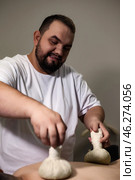 In a serene room, a man expertly performs a massage using herbal poultices. The soothing atmosphere enhances well-being as he focuses on delivering a rejuvenating experience. Стоковое фото, фотограф Aleksandr Golubev / Фотобанк Лори