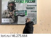 Информационный баннер Министерства обороны РФ с надписью "Служу России" на Гоголевском бульваре города Москвы в канун праздника "Дня защитника Отечества", Россия. Редакционное фото, фотограф Николай Винокуров / Фотобанк Лори