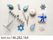 Hannukah composition with menorah, candles, donut and dreidels on white table. Стоковое фото, фотограф Pixel_shot / Фотобанк Лори