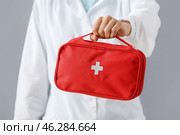 Doctor with first aid kit on grey background. Стоковое фото, фотограф Pixel_shot / Фотобанк Лори