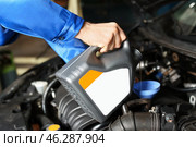 Male mechanic refilling car oil in service center. Стоковое фото, фотограф Pixel_shot / Фотобанк Лори