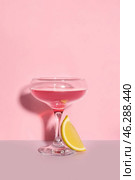 Glass of Cosmopolitan cocktail with lemon on color background. Стоковое фото, фотограф Pixel_shot / Фотобанк Лори