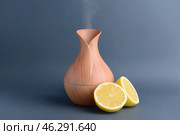 Aroma oil diffuser and citrus fruit on grey background. Стоковое фото, фотограф Pixel_shot / Фотобанк Лори