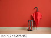 Stylish umbrella with gumboots near color wall. Стоковое фото, фотограф Pixel_shot / Фотобанк Лори