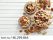 Bowls and scoop with various tasty nuts on wooden table. Стоковое фото, фотограф Pixel_shot / Фотобанк Лори