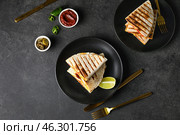 Plates with tasty quesadillas, lime, sauce and pickled jalapenos on dark background. Стоковое фото, фотограф Pixel_shot / Фотобанк Лори