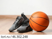 Trainers and ball for playing basketball on floor near white wall. Стоковое фото, фотограф Pixel_shot / Фотобанк Лори