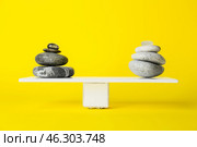 Spa stones on teeterboard against yellow background. Concept of balance. Стоковое фото, фотограф Pixel_shot / Фотобанк Лори